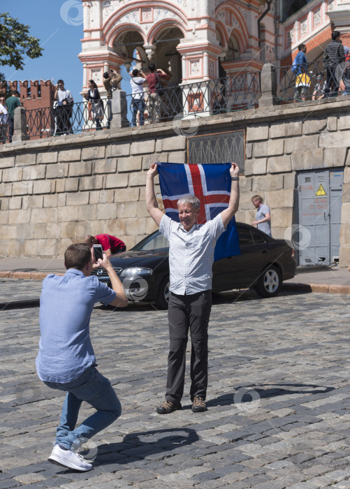 Скачать МОСКВА - 15 июня 2018 года: Фанатик Чемпионата мира по футболу из Исландии с флагом, сфотографированный на улицах 15 июня 2018 года в Москве, Россия фотосток Ozero