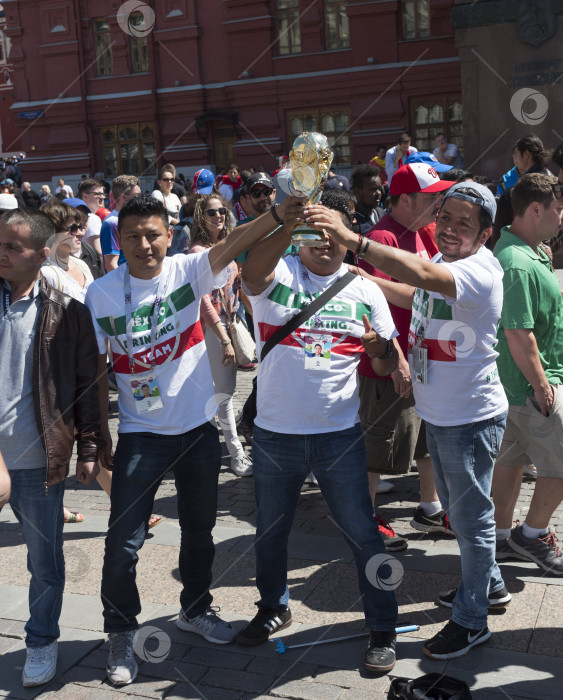 Скачать МОСКВА - 15 июня 2018 года: Фанатики Чемпионата мира по футболу в Мексике с флагами в своих типичных костюмах на улицах 15 июня 2018 года в Москве, Россия фотосток Ozero