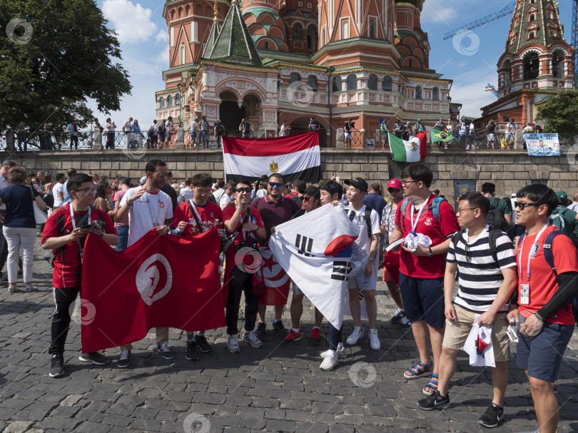 Скачать МОСКВА - 20 июня 2018 года: Фанатики Чемпионата мира по футболу из Туниса, Кореи, Египта с флагами в своих типичных костюмах на улицах 20 июня 2018 года в Москве, Россия фотосток Ozero