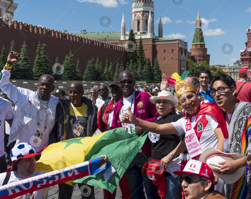 Скачать МОСКВА - 20 июня 2018 г.: Фанатики Чемпионата мира по футболу из Сенегала с флагами в своих типичных костюмах на улицах 20 июня 2018 г. в Москве, Россия фотосток Ozero