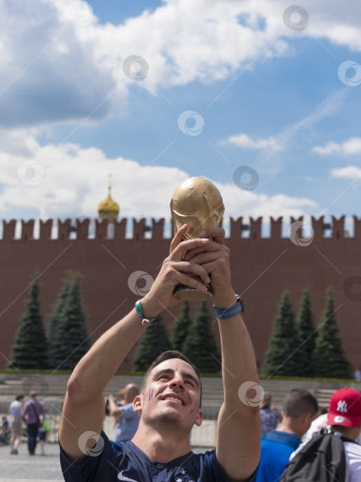 Скачать МОСКВА - 26 июня 2018 года: Фанаты Чемпионата мира по футболу во Франции держат кубок в своих типичных костюмах на улицах 26 июня 2018 года в Москве, Россия фотосток Ozero