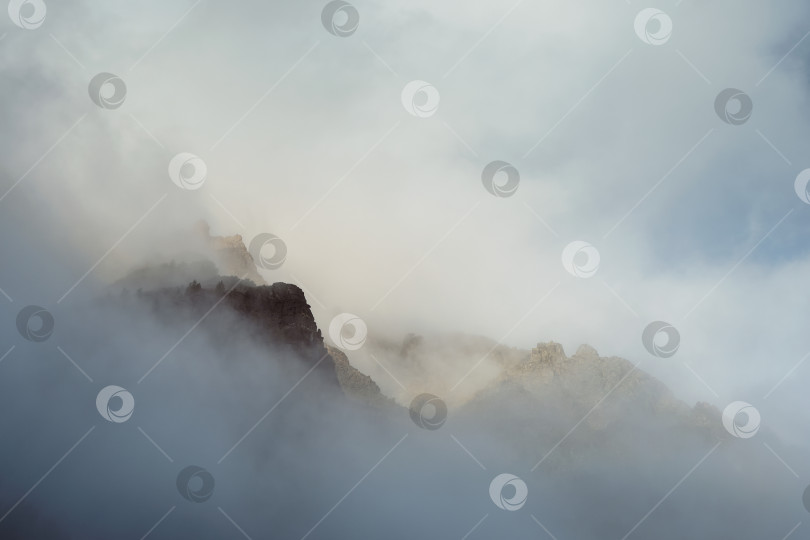 Скачать Край отвесной скалы едва виден из-за низких облаков и густого тумана. фотосток Ozero