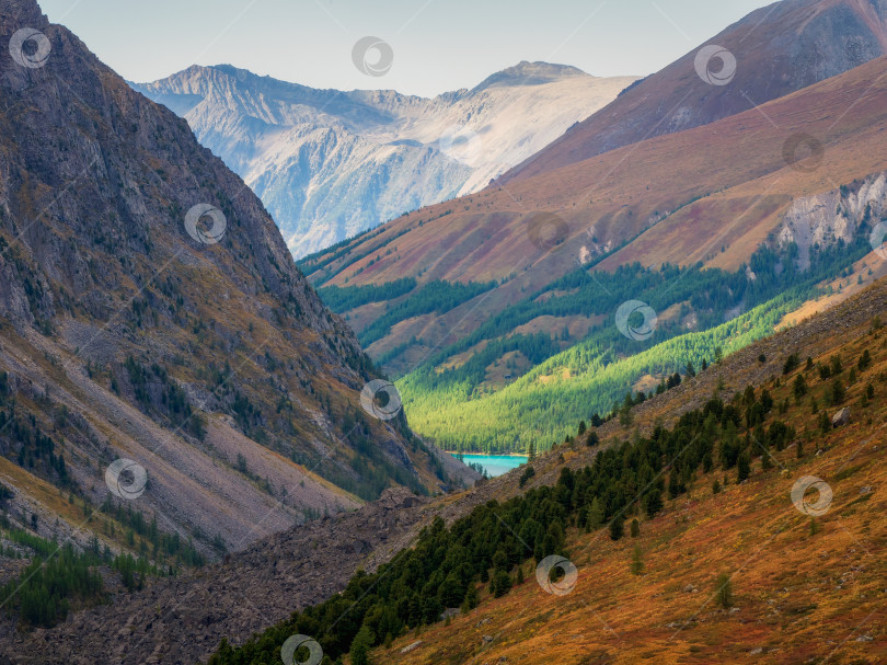 Скачать Красочный горный пейзаж с огромной горой, освещенной рассветным солнцем среди темных облаков. Потрясающий альпийский пейзаж с высокой горной вершиной на закате или восходе солнца. фотосток Ozero