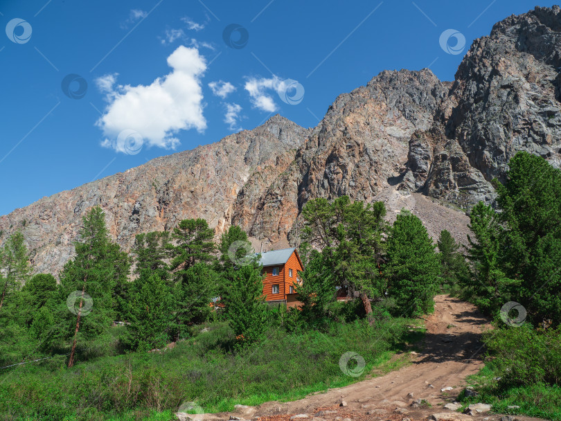 Скачать Деревянный отель в горах. Оранжевый гостевой дом с темной крышей. фотосток Ozero