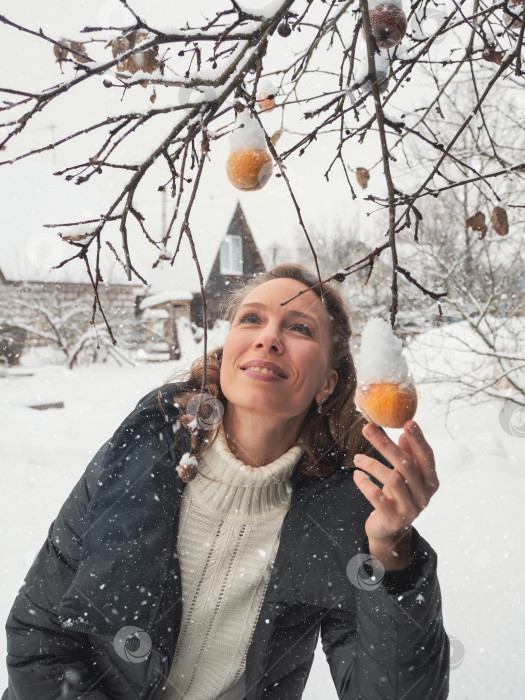 Скачать Фотография милой женщины средних лет с замороженной яблочной веточкой зимой фотосток Ozero