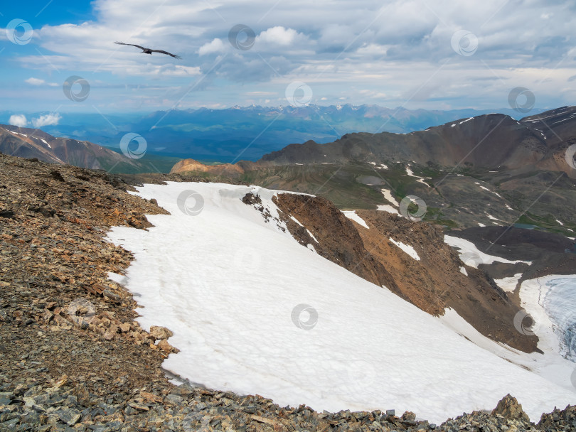 Скачать Яркий альпийский пейзаж с ледниковыми горами под голубым облачным небом. Живописный горный пейзаж в солнечную погоду. Прекрасный атмосферный вид с каменного холма, покрытого снегом, на заснеженный горный хребет. фотосток Ozero