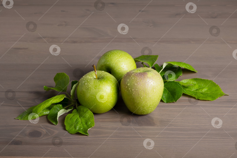 Скачать Свежие спелые зеленые яблоки и листья яблони на деревянном фоне фотосток Ozero