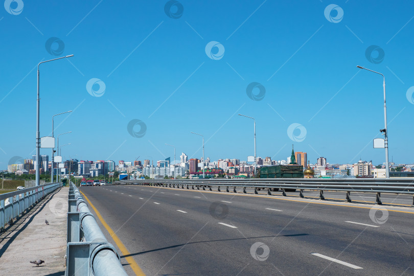 Скачать Городской мост, асфальтированное шоссе. Современные здания с пустой дорогой под голубым небом, Барнаул, Россия. фотосток Ozero
