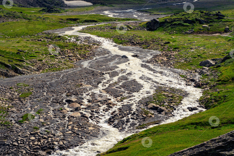 Скачать Русло горной реки обмелело после схода талых вод, сухого сезона в горах. фотосток Ozero