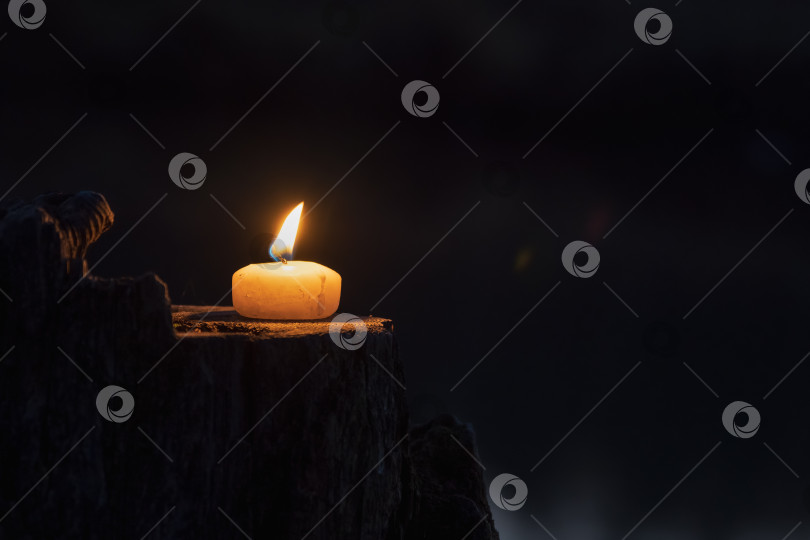Скачать Горящая свеча в ночи на темном фоне. фотосток Ozero