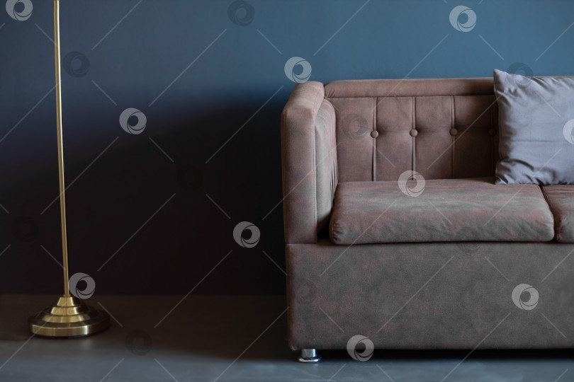 Скачать коричневый диван у темно-синей стены, пространство для копирования. темный интерьер. фотосток Ozero