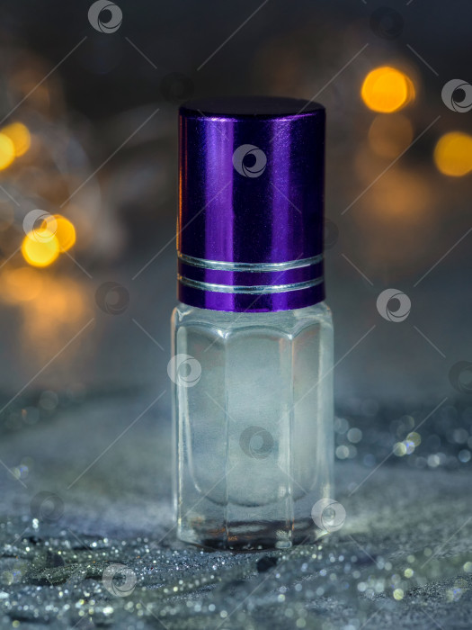 Скачать Концентрированный парфюм в мини-флаконе с мускусом на черном праздничном фоне фотосток Ozero