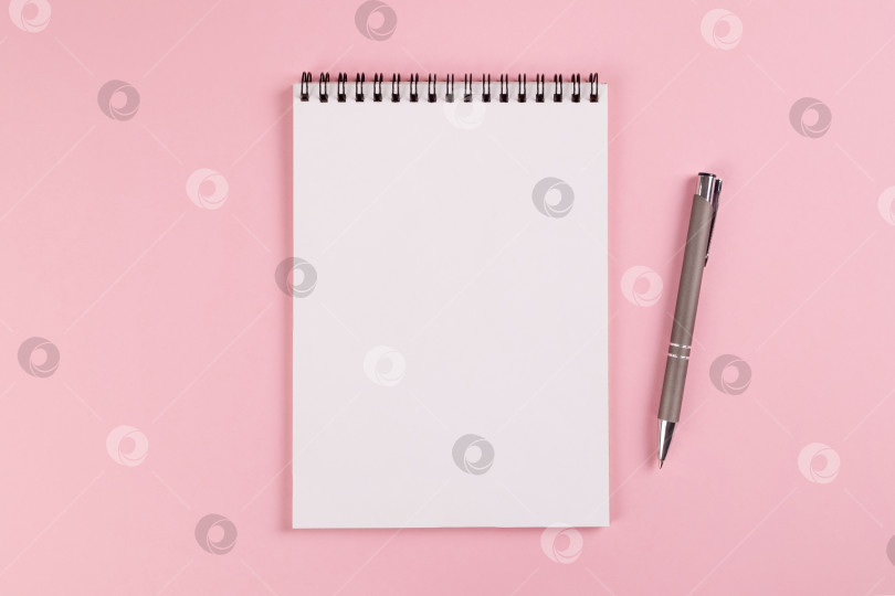 Скачать Блокнот с чистой страницей и шариковая ручка лежат на розовом фоне фотосток Ozero