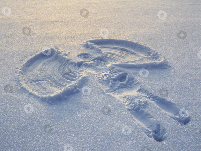 Скачать Снежный ангел, созданный на белом снегу. Плоский вид сверху фотосток Ozero