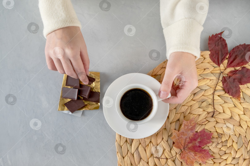 Скачать Крупным планом женские руки держат чашку кофе и кусочки шоколада. фотосток Ozero