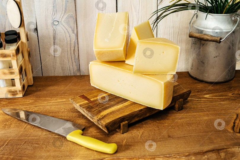 Скачать Большие куски нарезанного сыра на деревянном столе фотосток Ozero