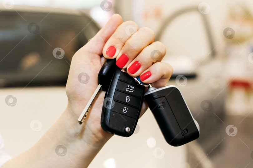 Скачать Ключи от машины в женской руке на автосалоне фотосток Ozero