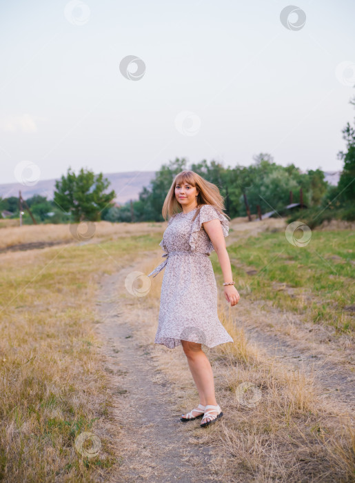 Скачать Молодая женщина прогуливается по поляне. Прогулка в парке или лесу. Отдых на свежем воздухе. Атмосфера свободы и природы. фотосток Ozero