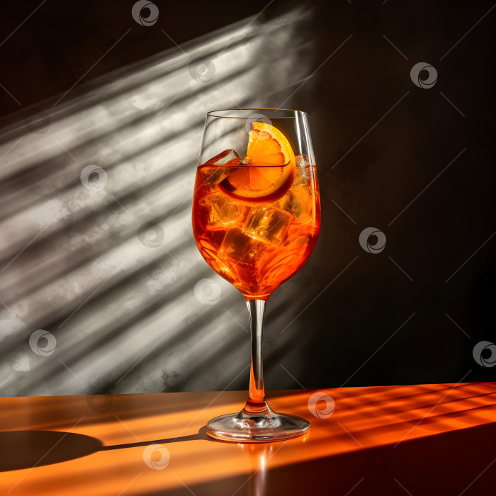 Скачать Коктейль Aperol spritz в большом бокале для вина со льдом и кровавыми апельсинами на деревянном столе в жестком освещении с тенями, летний итальянский освежающий холодный алкогольный напиток. Апельсиновый коктейль. Порождающий искусственный интеллект фотосток Ozero