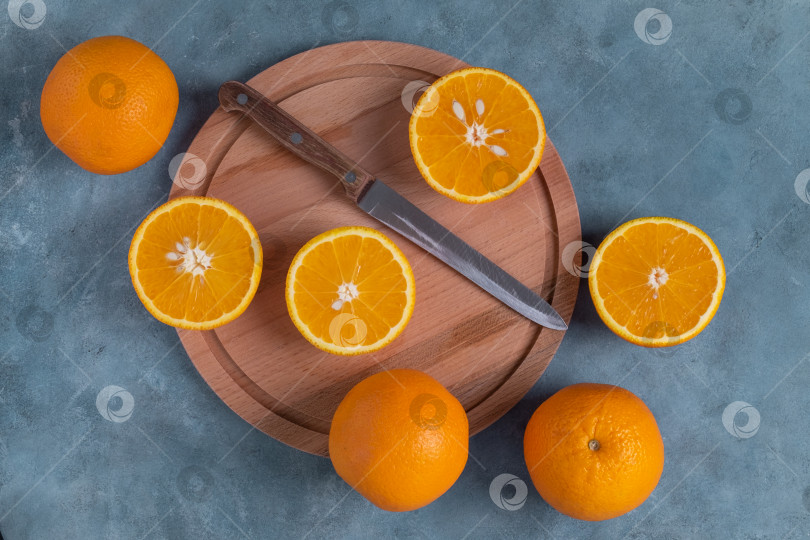 Скачать Крупный план спелых целых и разрезанных пополам апельсинов сверху. фотосток Ozero