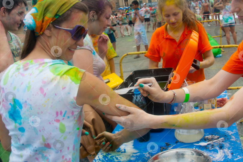 Скачать НОВОСИБИРСК, РОССИЯ - 28 июня 2014 года: Фестиваль красок. Нарисуйте на руке девочки разные цвета. фотосток Ozero