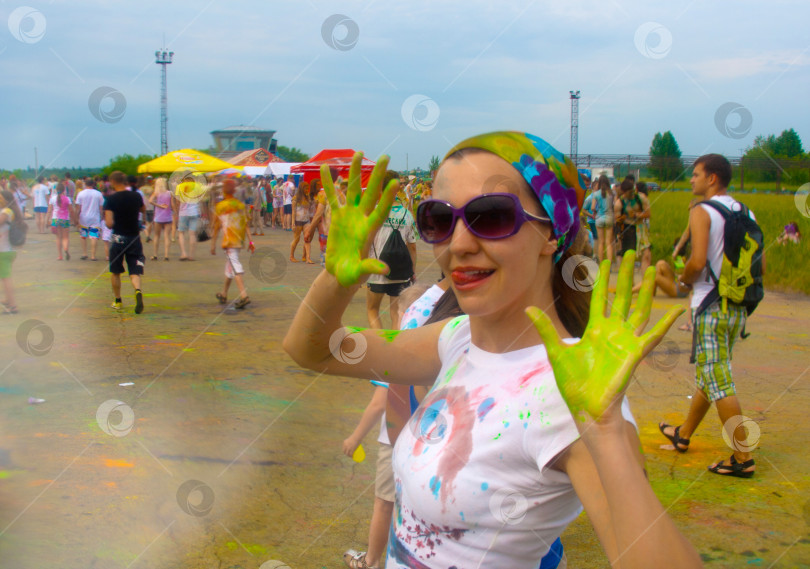 Скачать НОВОСИБИРСК, РОССИЯ - 28 июня 2014 года: Фестиваль красок. Девушка на переднем плане в ярко-зеленых лодочках. фотосток Ozero