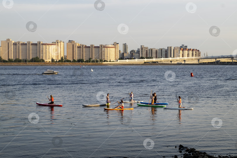 Скачать Вид на реку в городе с людьми, плавающими на стоячем весле. фотосток Ozero