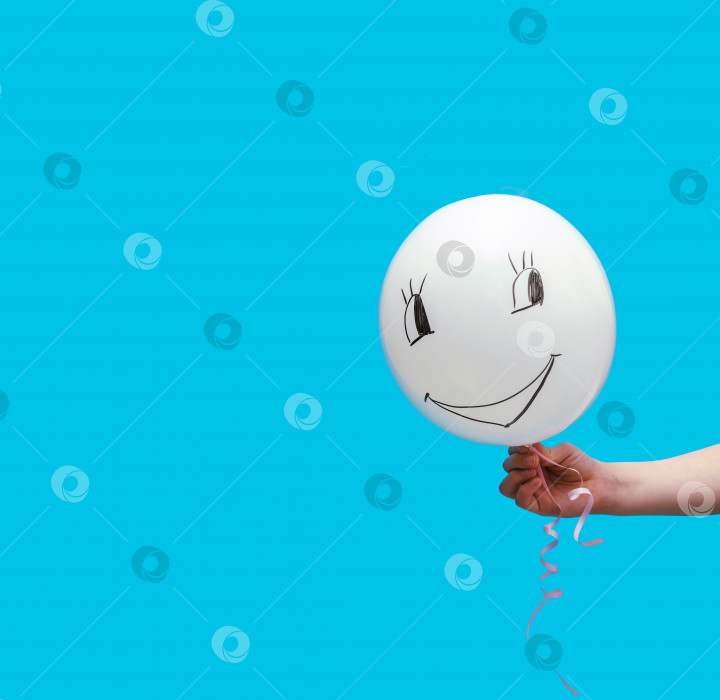 Скачать Белый воздушный шар на синем фоне. На шаре нарисована забавная рожица. фотосток Ozero