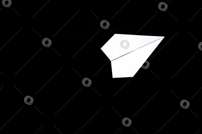 Скачать Самолет, сделанный из бумаги на черном фоне.Самолет сделан вручную. Бумага для оригами. Тема путешествий. фотосток Ozero