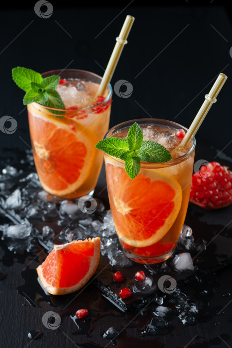Скачать Грейпфрутово-гранатовый коктейль или моктейл, освежающий летний напиток с колотым льдом и газированной водой фотосток Ozero