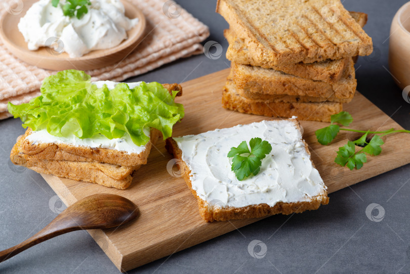 Скачать Хлеб со сливочным сыром на сером столе. Цельнозерновой хлеб с семечками фотосток Ozero