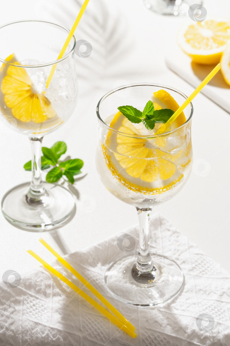 Скачать Лимонный коктейль с игристым вином и льдом в бокале, изолированном на белом фоне фотосток Ozero