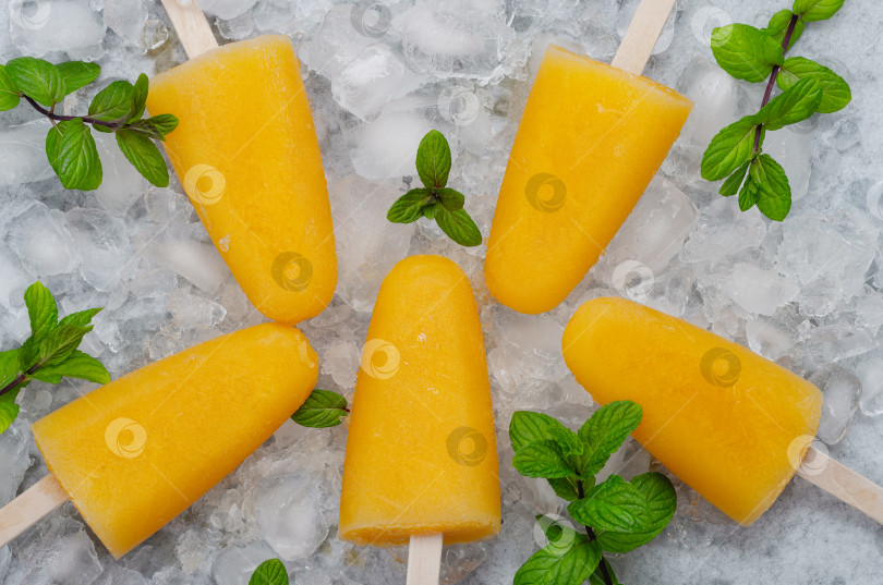 Скачать Вкусное домашнее фруктовое мороженое с апельсиновым соком, фруктовые леденцы на палочках, Кубик льда, вид сверху, Плоская выкладка. Апельсиновое мороженое фотосток Ozero