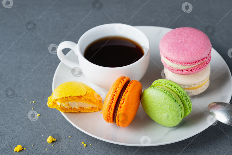 Скачать Французское цветное миндальное печенье с белой чашкой кофе на сером фоне фотосток Ozero
