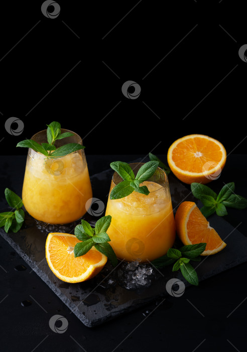 Скачать Холодный летний апельсиновый лимонад с мятой и льдом в бокале. Скопируйте место для текста фотосток Ozero