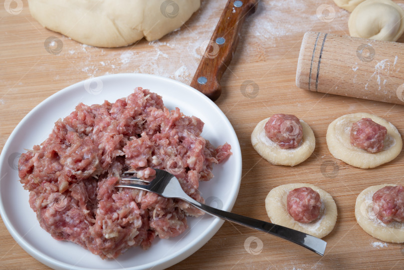 Скачать Процесс приготовления домашних пельменей. Выложите мясной фарш на тесто. Русская кухня. фотосток Ozero