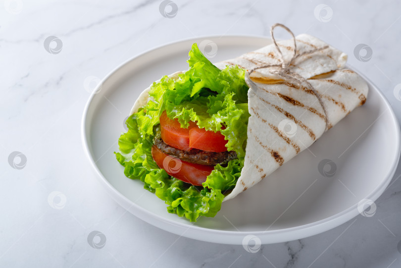 Скачать Оберните сэндвич мясным стейком, помидорами и зеленью на белом фотосток Ozero