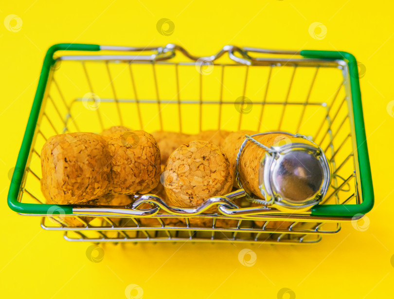 Скачать Маленькая металлическая тележка для покупок в супермаркете на желтом фоне. фотосток Ozero