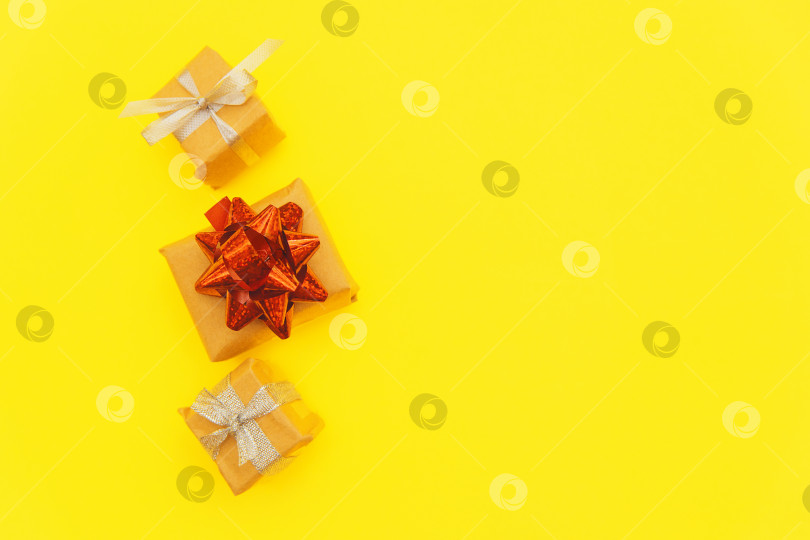 Скачать Маленькие подарочные коробки на желтом фоне.Коробки празднично упакованы. Концепция праздника и подарков. фотосток Ozero