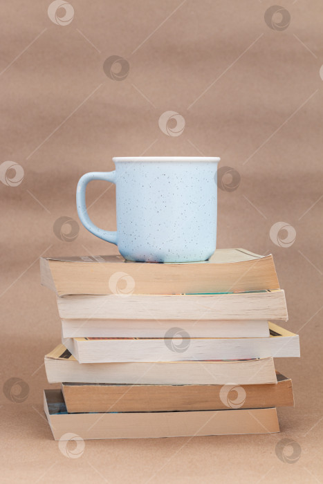 Скачать стопка старых книг с чашкой кофе или чая на бежевом фоне фотосток Ozero