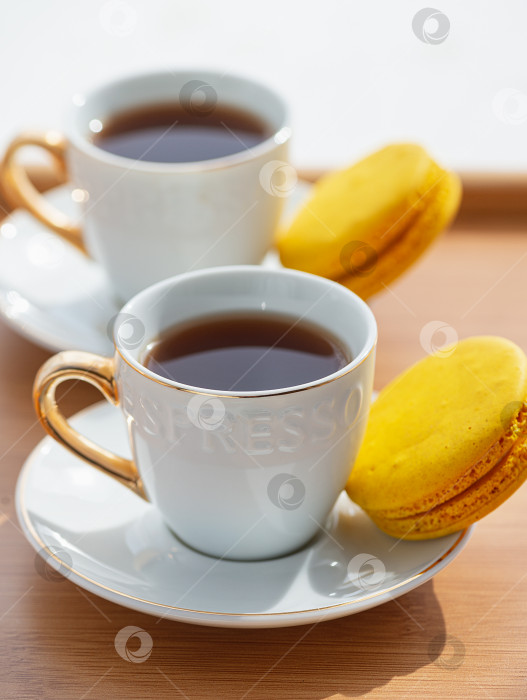Скачать Кофейная чашка и миндальное печенье на деревянном столе. фотосток Ozero
