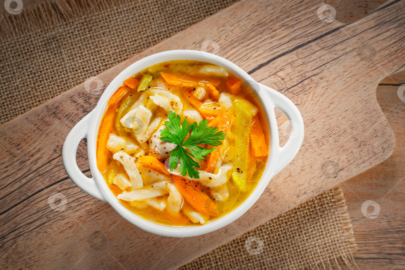Скачать Русский домашний куриный суп с лапшой и овощами в белой тарелке на деревянном фоне фотосток Ozero