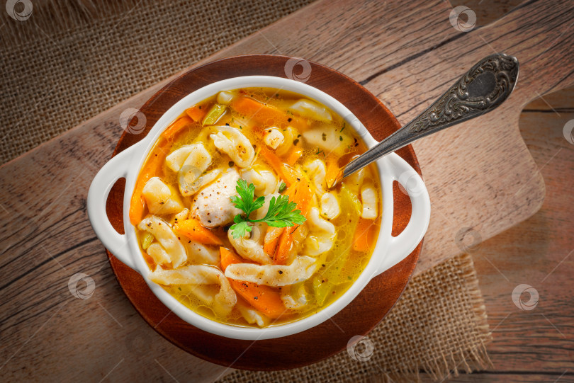 Скачать Русский домашний куриный суп с лапшой и овощами в белой тарелке на деревянном фоне фотосток Ozero