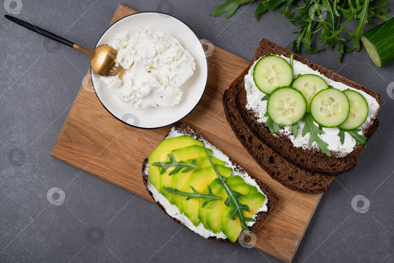 Скачать Полезный бутерброд с белым творогом, авокадо, огурцом и рукколой фотосток Ozero
