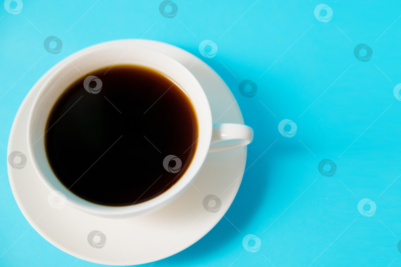 Скачать Белая чашка с черным кофе на синем фоне. Утренний завтрак.Пустое место для текста. фотосток Ozero