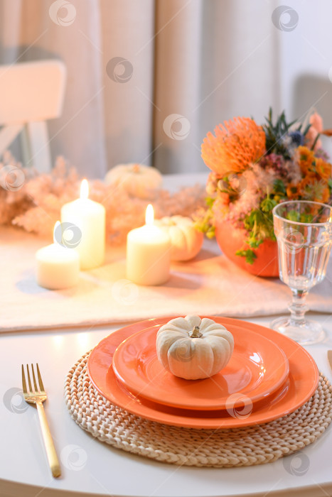 Скачать Сервировка стола на день благодарения с осенними украшениями, центральным элементом являются разноцветные цветы в тыкве в качестве вазы. фотосток Ozero