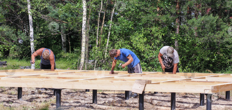 Скачать Рабочие возводят деревянное основание загородного дома. фотосток Ozero