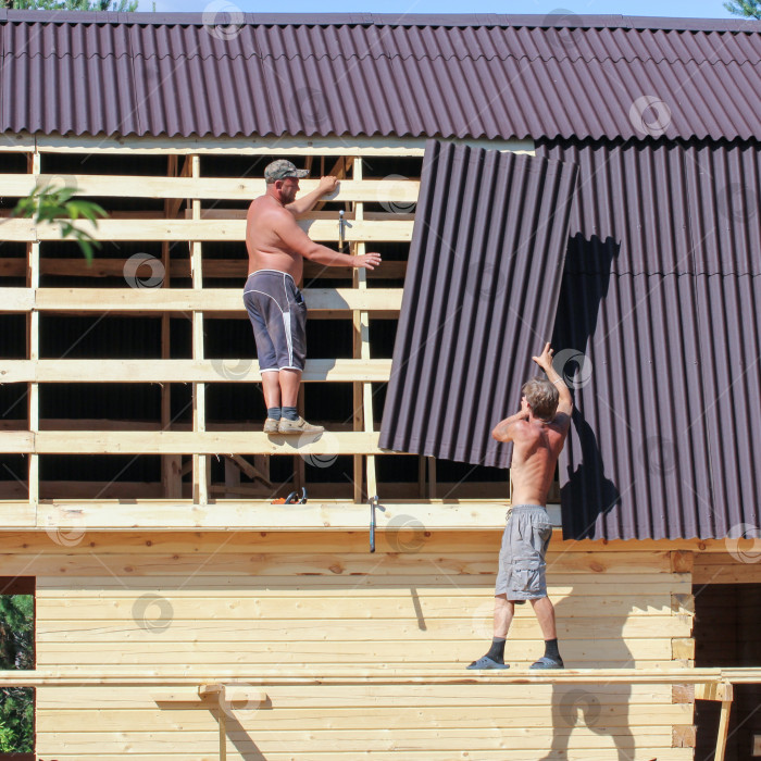 Скачать Двое рабочих на загородной стройке. фотосток Ozero