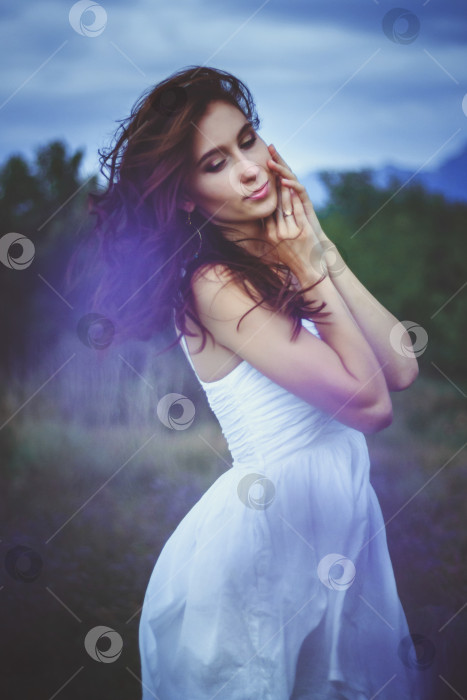Скачать Красивая женщина стоит в поле.Ветер развевает волосы девушки. пасмурный день.Концепция красоты и экологии. фотосток Ozero