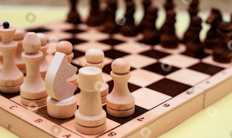 Скачать Шахматные фигуры крупным планом стоят в ряд на доске. Черно-белые фигуры разных обозначений. фотосток Ozero